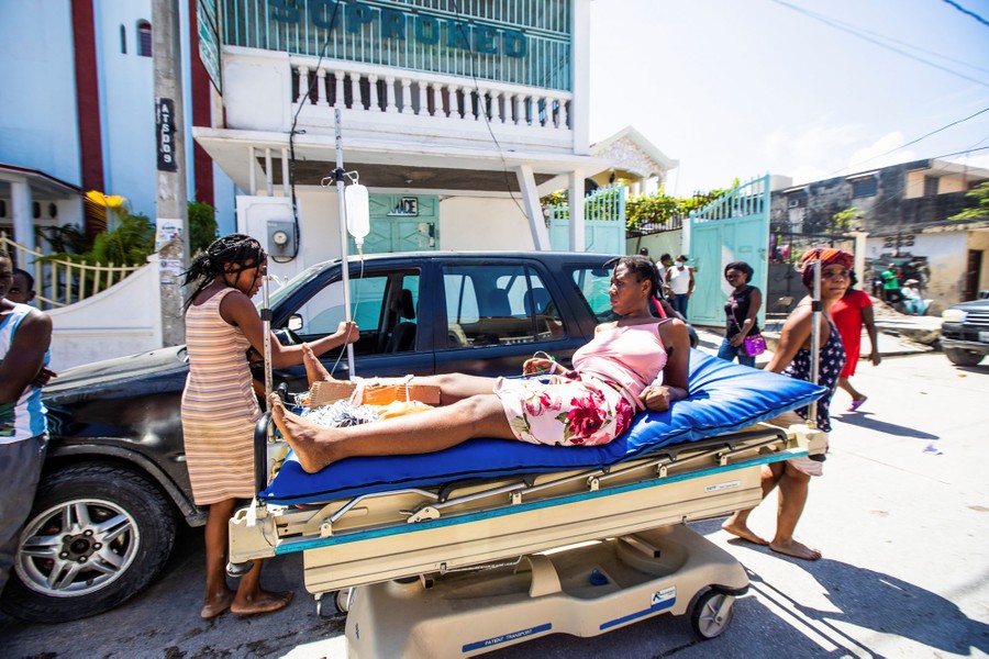 A woman injured during the earthquake lies on a stretcher in Les Cayes.