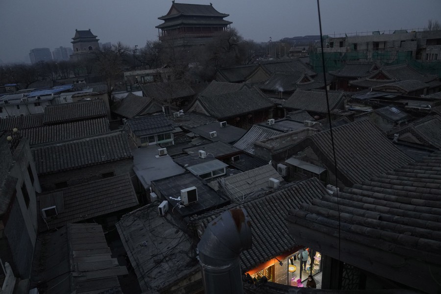 A view of rooftops in Beijing, with a small view of a lit walkway