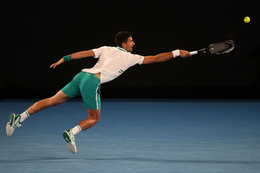 Novak Djokovic reaches with his whole body to return a volley.