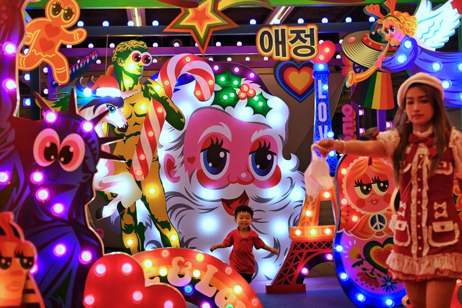A child runs through colorful Christmas decorations.