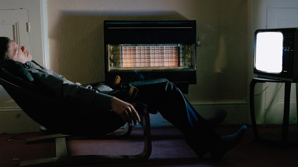 man sleeps in front of a TV