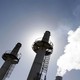 Three smokestacks backlit by the sun