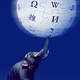 An elephant balances the Wikipedia logo with its trunk.