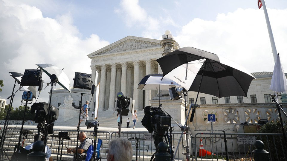 Television camera crews wait outside the Supreme Court