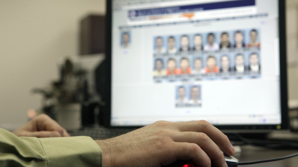 An officer looks through photos in a federal facial-recognition system