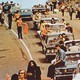 Concertgoers at Woodstock pile outside in cars.