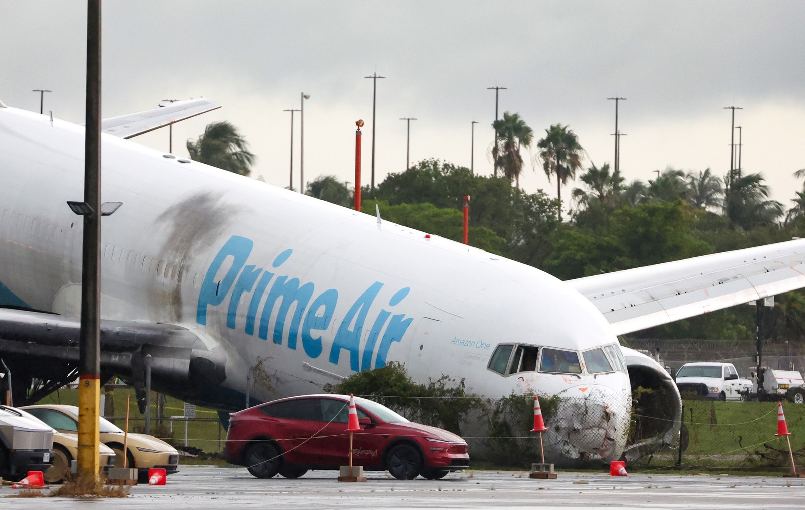 A large Amazon cargo plane sits on its nose after a crash.