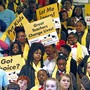 People hold signs reading "Let me learn," "United for school choice," and "Great teachers change lives."