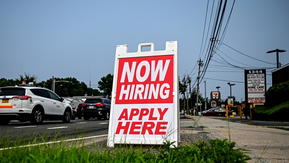 Photo of a "Now Hiring" sign.