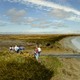 Researchers stand near water from a former industrial salt pond as it flows into the San Francisco Bay 