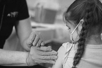 A child in a mask getting a shot