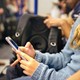 A teenager uses an iPhone while riding on public transit.