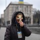 A religious woman holds a cross as she prays on Independence Square in Kyiv.