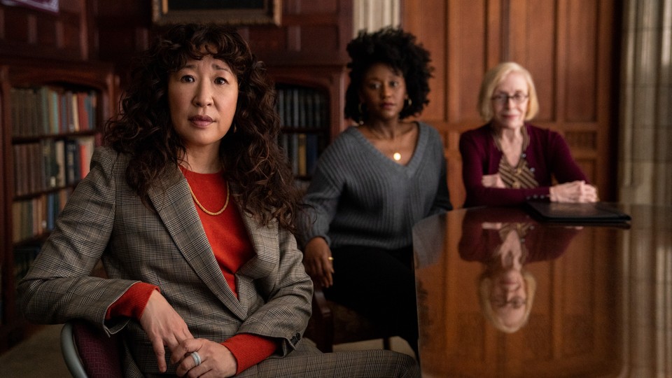 Sandra Oh sitting at a table in The Chair