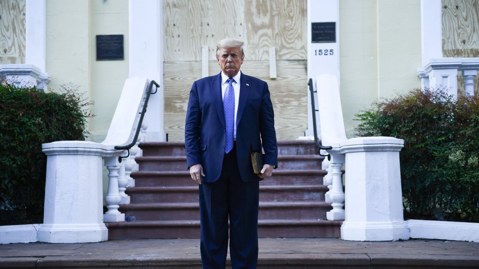 Donald Trump stands in front of a church holding a Bible