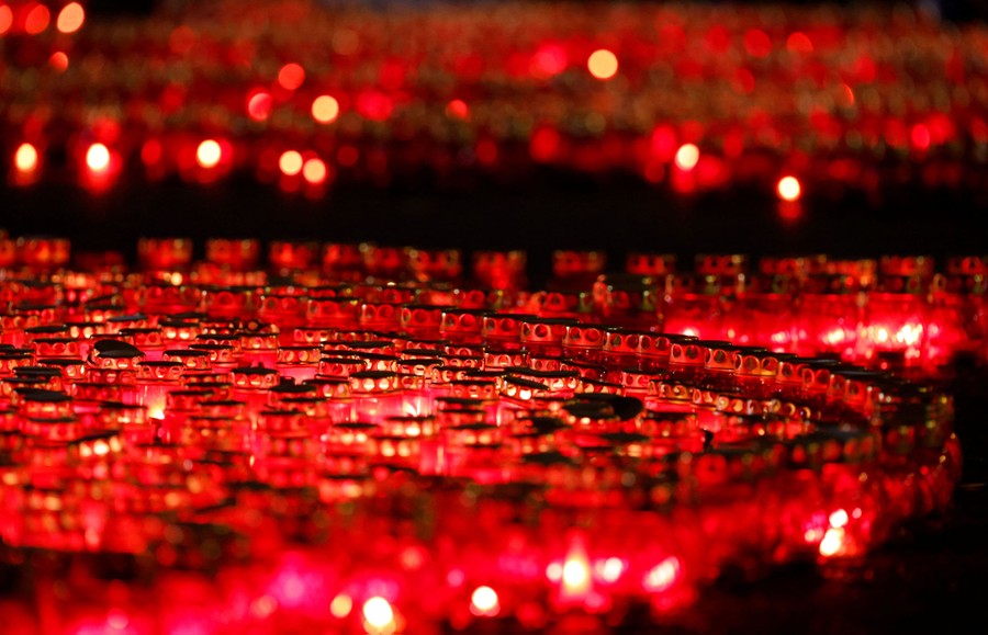 Many lit candles in glass containers