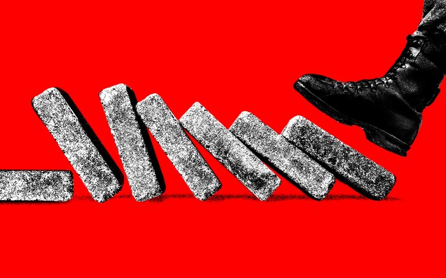 A foot in a military boot comes down on the first of a line of bricks set up like dominoes to topple