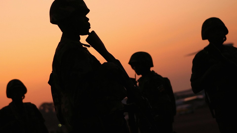 Ugandan soldiers of the African Union peacekeeping mission to Somalia stand before sunrise.