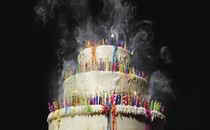 A birthday cake packed with colorful candles that have been blown out
