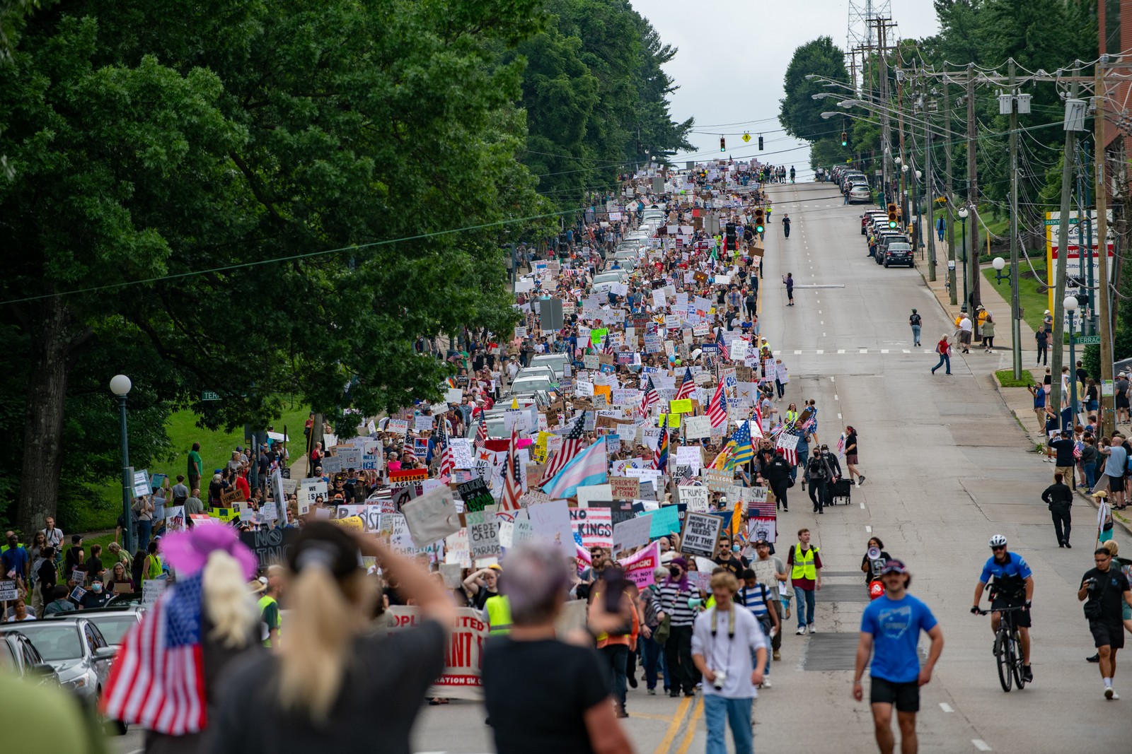 A long line of demonstrators march down a city street.