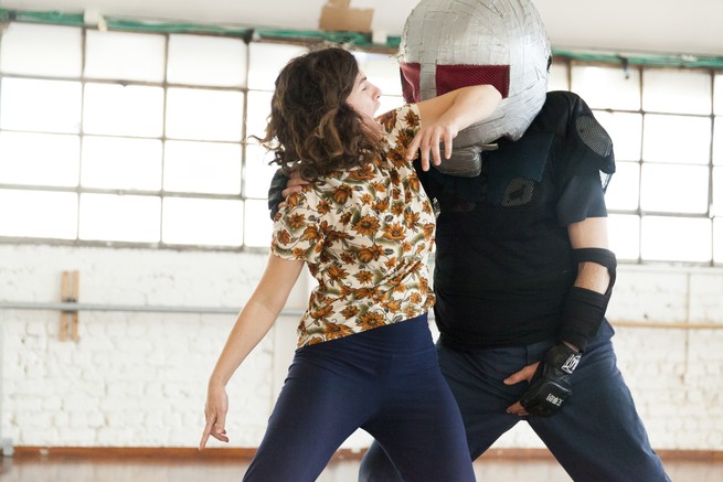 A woman elbows a simulated assailant during a self-defense class.