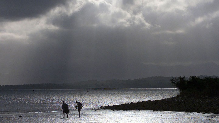 An afternoon storm looms above fishermen in Suva, Fiji