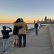 People look at the Chicago skyline at dusk.