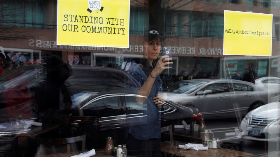 A store displays signs in its windows supporting the "A Day Without Immigrants" strike on February 16.