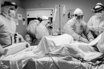 Doctors wearing PPE surrounding a coronavirus patient.