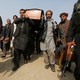 Afghan men carry a coffin.