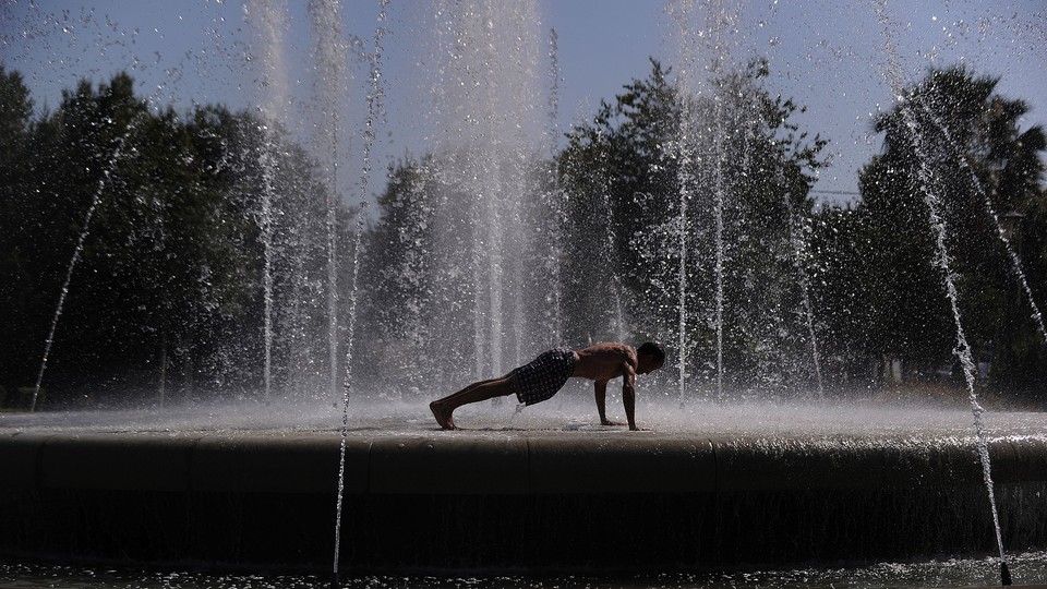 a man doing a pushup in the middle of a large water fountain