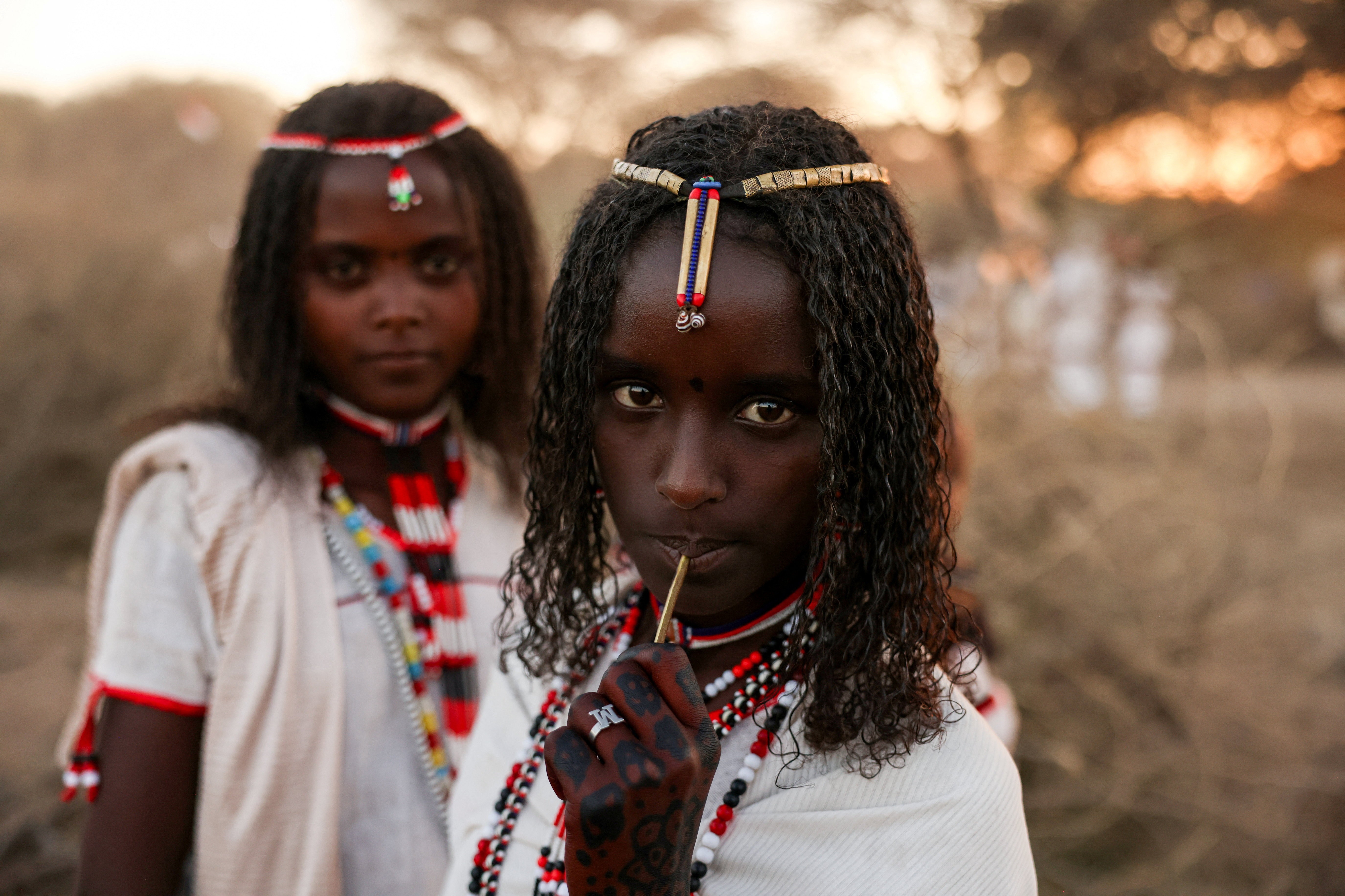 Two young people pose, dressed in traditional clothes.