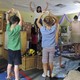 A teacher instructs preschool students in yoga. 