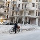 A man on a bicycle inspects a damaged building in eastern Aleppo in 2015.