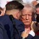 Donald Trump with blood on his face, surrounded by Secret Service agents
