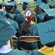 A photo showing students wearing graduating caps, one of which is covered in caution tape.