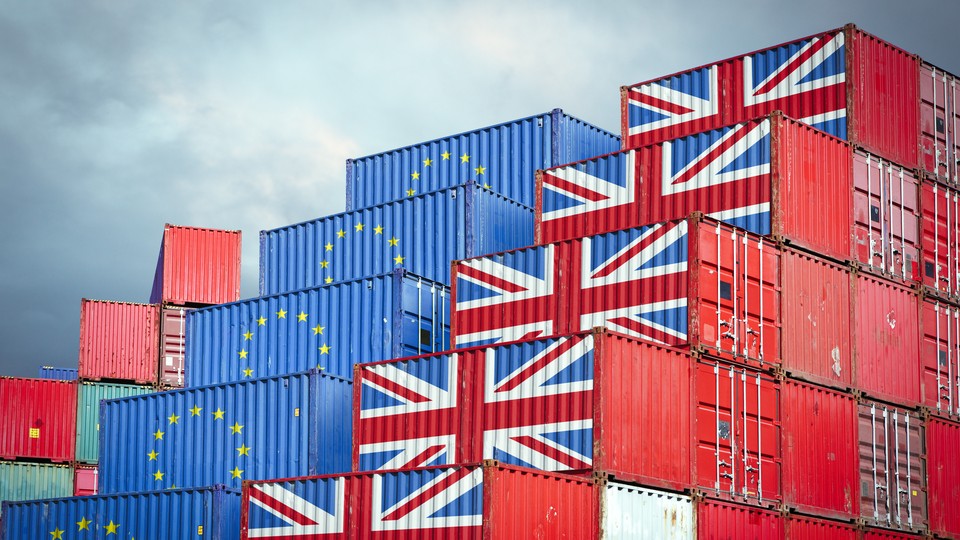 Shipping containers painted with the European flag and the Union Jack sit next to each other.
