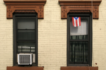 The flag of Puerto Rico hanging from a sash window of a house in Brooklyn, New York City