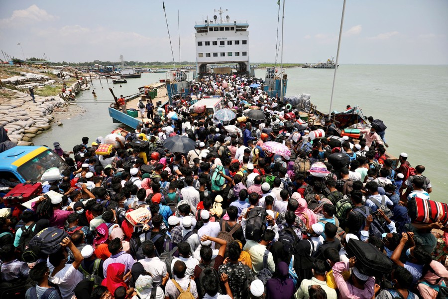 Hundreds of people crowd together to board a passenger ferry.