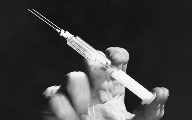 a hand holding a syringe