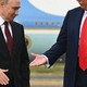 A photograph shows Trump extending a hand to Putin, who appears to hesitate, looking away from Trump with his hand pointing down.