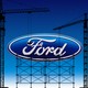 An image of the Ford logo surrounded by cranes