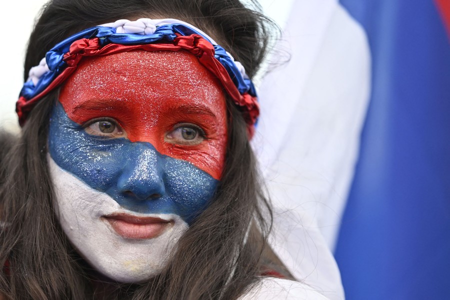 A supporter of a presidential candidate wears red, white, and blue full-face makeup.