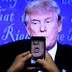 A journalist records a video from screen as Republican U.S. presidential nominee Donald Trump speaks during the first presidential debate with U.S. Democratic presidential candidate Hillary Clinton at Hofstra University.