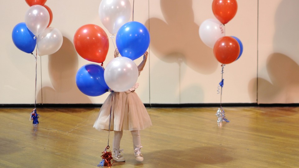 A little girl plays with balloons