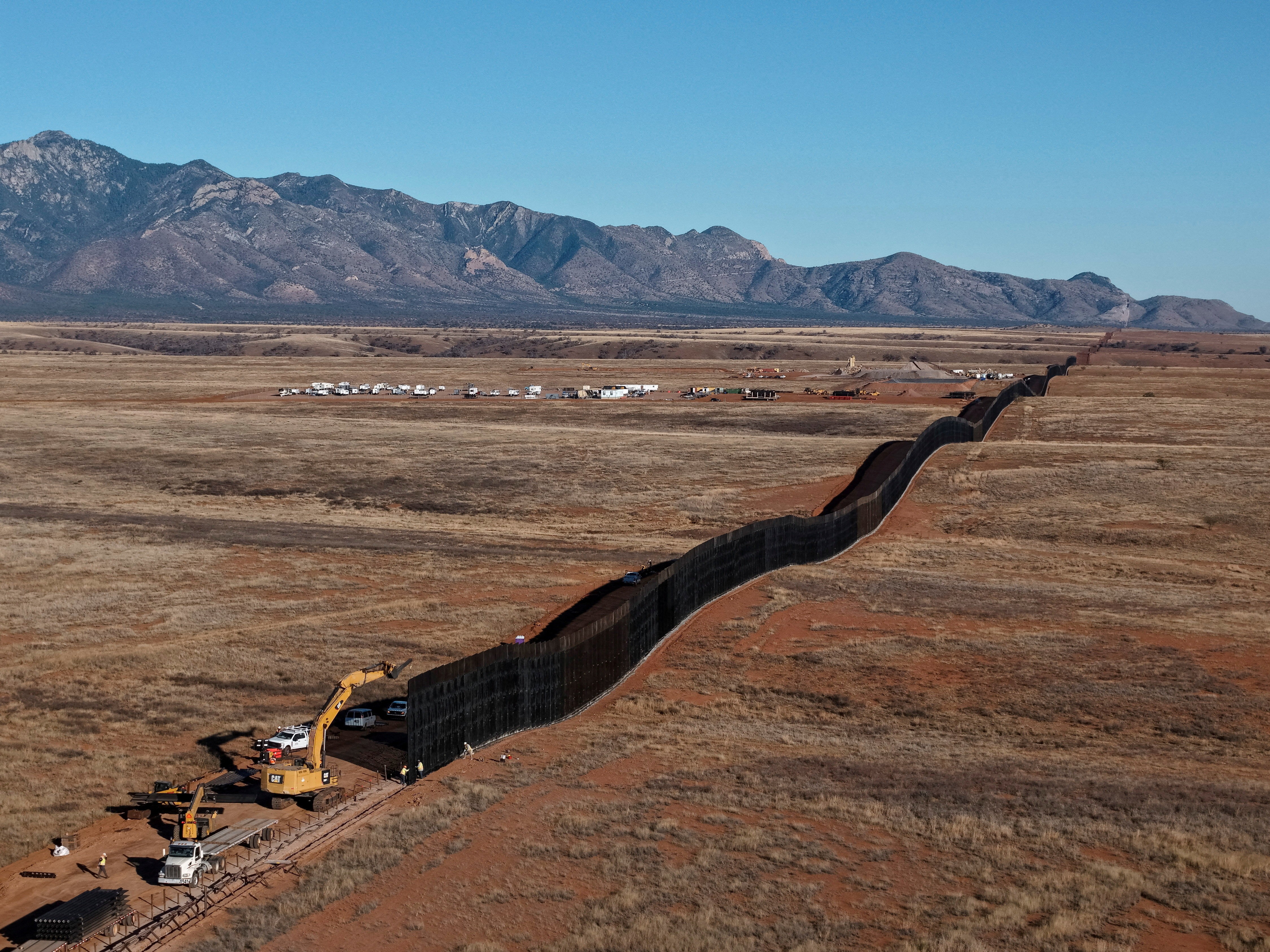 A drone view of a new section of border wall being constructed in an Arizona desert