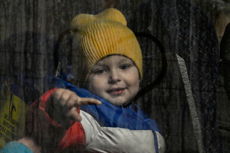 A child traces the figure of a heart on a bus window.