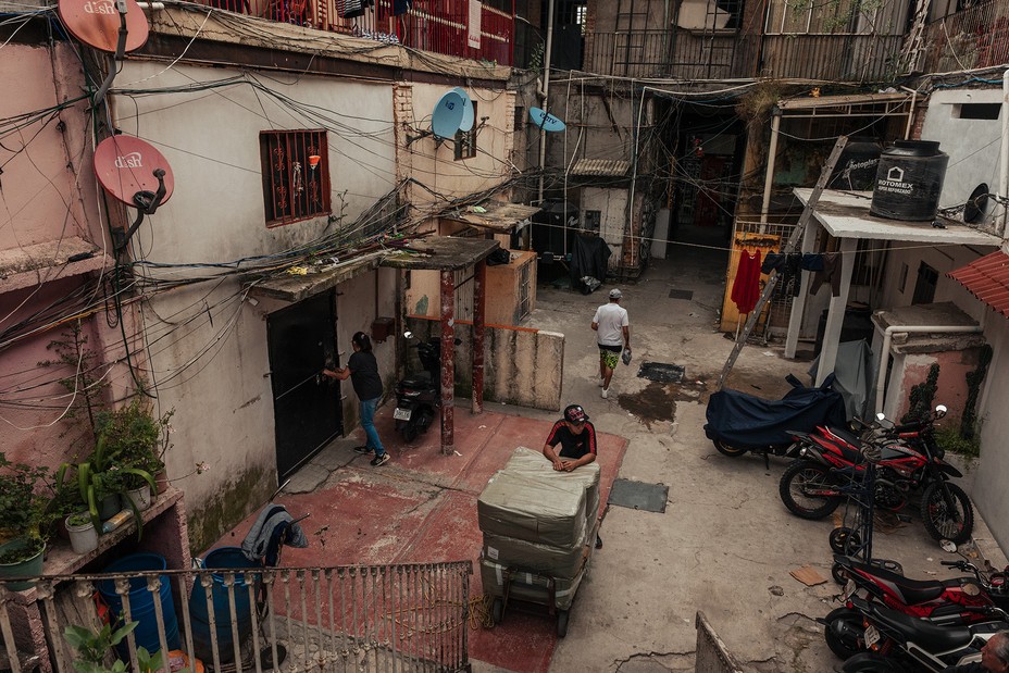 people mill about in an open space between squat concrete homes