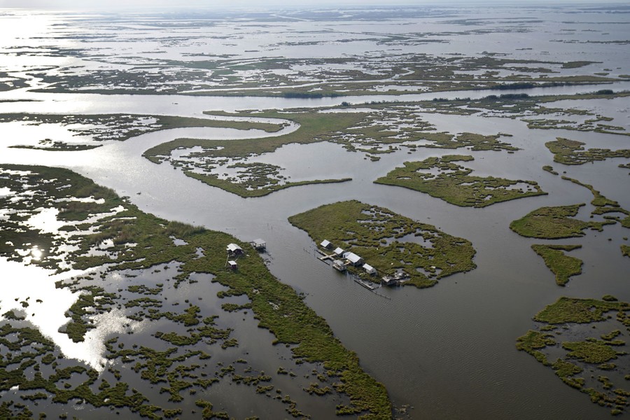 An aerial view of small islands in a broad marshy area.