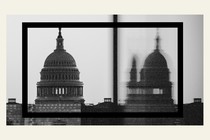 A black-and-white image of the U.S. Capitol, clear on the left and reflected blurrily on the right